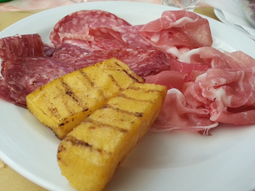 Sliced ham and salami with polenta